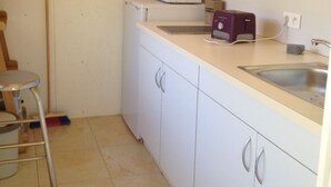A small kitchen with white cabinets, a microwave, a toaster, and a sink. - Ouemoplage Araucaria independent studio in a villa (Magenta)