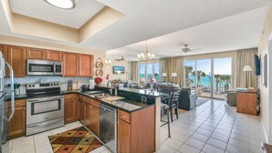 A modern kitchen with stainless steel appliances, wooden cabinets, and a large island. - Janie & Charlies Beach Escape
 2br 2 bath ,Beautiful view of the Gulf of Mexico. (Miramar Beach)