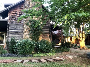 Escape to a serene natural oasis with a beautifully maintained garden and a charming stone building.