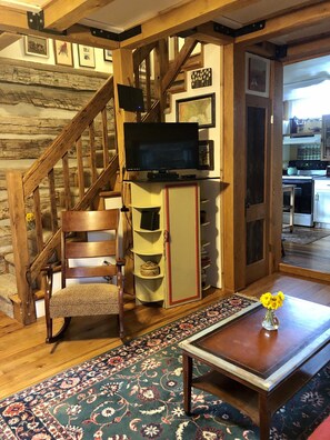 Relax in this inviting living room with a flat-screen TV, comfortable chair, and cozy seating area.