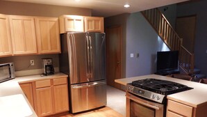 A modern kitchen with stainless steel appliances, wooden cabinets, and a wooden floor. - Greenwater chalet/cabin - 3 bed + loft - 2 full baths (Enumclaw)