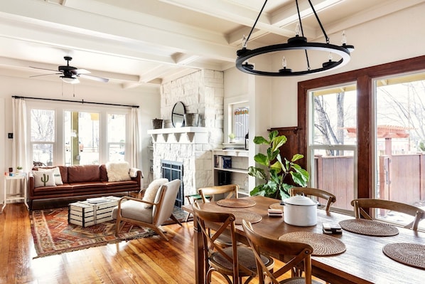 Cozy living area with a fireplace, dining table, and bookshelf.
