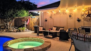 An outdoor patio area with a hot tub, seating, and string lights. - Premier Secluded Oasis w/ Diving Pool, Hot Tub, Koi Pond & Outdoor Shower (Plano)