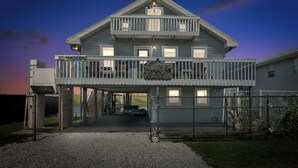 Ein zweistöckiges Haus mit Balkon, überdachter Veranda und Auffahrt.