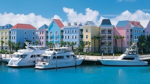 A marina with colorful buildings and yachts docked.