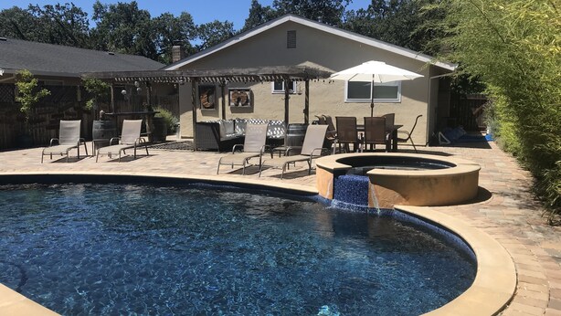 A swimming pool with lounge chairs and a hot tub, surrounded by a patio area with outdoor furniture. - Sonoma Retreat w/ Pool, Spa & Spacious Yard – Near Wineries & Sonoma Plaza (Sonoma)
