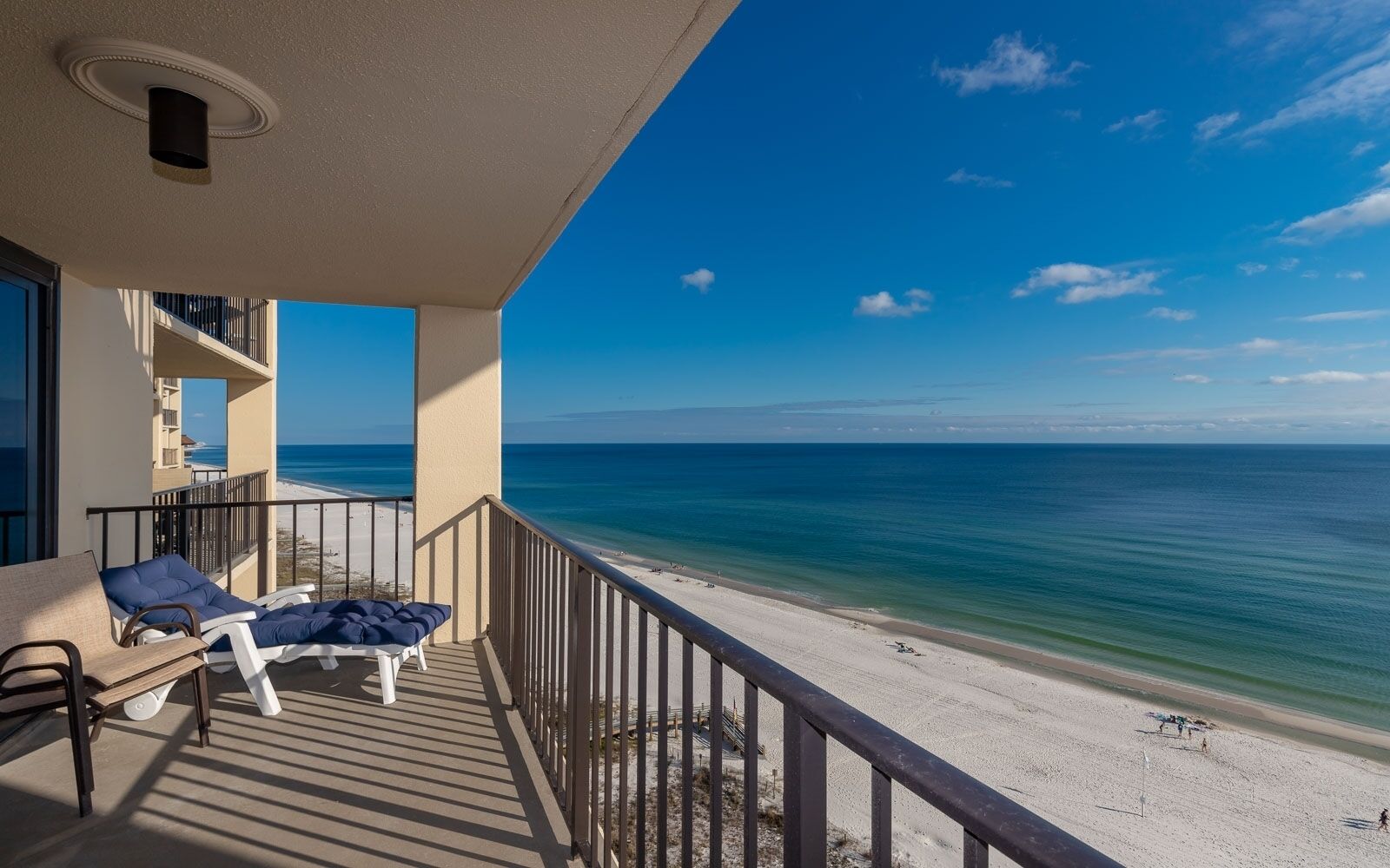 A balcony with a view of the beach and ocean.