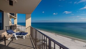 A balcony with a view of the beach and ocean.