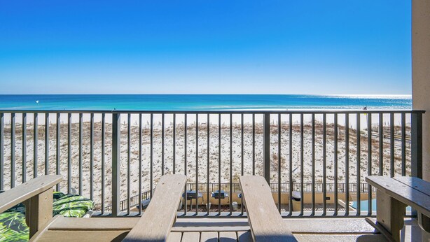 A beach view from a balcony with a railing, wooden chairs, and a table. - 3rd Floor ~ 2 Bedroom @ Phoenix 10 ~ (Orange Beach)