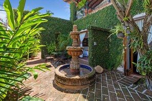 A courtyard with a decorative fountain, potted plants, and a brick floor. - Private Villa Downtown PV, 3 blocks to Beach, Private Pool, 360 rooftop views. (Puerto Vallarta)