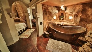 A luxurious bathroom with a large bathtub, a stone wall, and a canopy bed. - Stay in the Zion themed inn!3348714 a new 2nd rental. The Silo Inn (Washington)