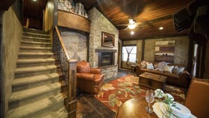 A cozy living room with a fireplace, a stone wall, a staircase, and a dining area with a table and chairs. - Stay in the Zion themed inn!3348714 a new 2nd rental. The Silo Inn (Washington)