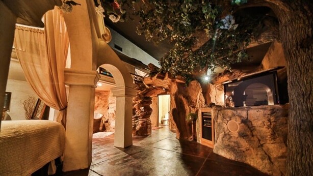 A room with a bed, a stone wall, a fireplace, and a tree-like structure with foliage. - Stay in the Zion themed inn!3348714 a new 2nd rental. The Silo Inn (Washington)