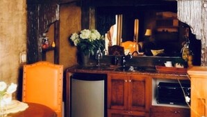 A rustic kitchen with wooden cabinets, a built-in oven, and a small refrigerator. - Stay in the Zion themed inn!3348714 a new 2nd rental. The Silo Inn (Washington)