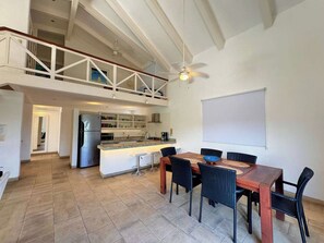 Een ruime keuken met een eetgedeelte, een balkon en een plafondventilator.