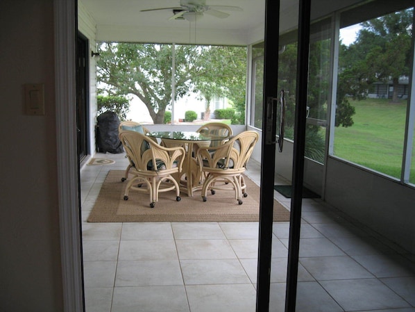 Relax in a serene setting with a patio area featuring a round table and four wheeled chairs.