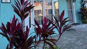 A two-story building with a balcony, a number '46' sign, and potted plants in the foreground. - CHARMING 2 BEDROOM HOME: 3 BEDS, SLEEPS 1-5, 24hr SECURITY, PRIVATE POOL & BEACH (Negril)