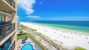 A beachfront hotel with a pool, beach umbrellas, and a clear view of the ocean. - Beautiful 2BR Gulf Front Condo - Phoenix V 1106 (Orange Beach)