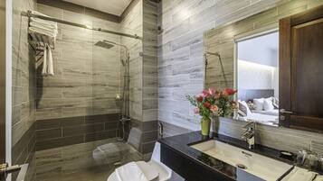 A modern bathroom with a shower, toilet, and sink, featuring wooden wall tiles and a large mirror.