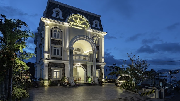 A grand hotel with a prominent arched entrance, a balcony, and a well-lit facade. - Minh Chien Hotel (Xuan Huong - Da Lat)