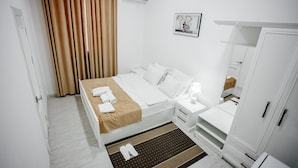 Een hotelkamer met een bed, nachtkastje, kast en een badkamer.