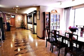 A hotel lobby with a checkered floor, a reception desk, and a seating area with chairs and a table. - Hotel Halftime (Nara)