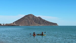 Two kayakers on a calm sea with a mountain in the background. - Stella del Mar (San Felipe)