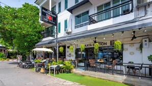 A restaurant with outdoor seating, a sign for 'KATA STATION', and a parked motorcycle. - Kata Station (Karon)