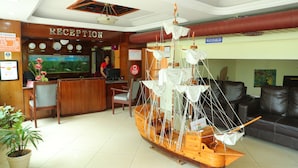 A reception area with a wooden reception desk, a large aquarium, and a model ship.