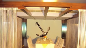 A dining area with a table set for four, featuring a decorative anchor centerpiece.