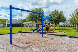 Children can play on the swing set, slide, and play structure in this neighborhood playground.