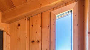 A wooden interior with a large window offering a mountain view. - Haus Lasaun (Bressanone)