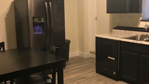 A compact kitchen with a black refrigerator, a sink, and a countertop. - Royal Retreat 3 Downtown South Charleston  (South Charleston)