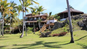 A multi-story resort with a wooden deck and a staircase leading to the upper levels. - Villa Natasha (Las Galeras)
