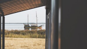 A view from inside a building looking out to a dock with a boat.
