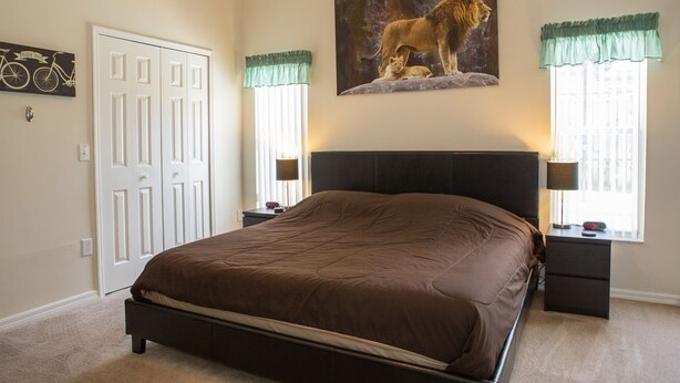 A bedroom with a large bed, two bedside tables, a nightstand, a door, and a window with curtains. - Ip60433 - Wellington - 4 Bed 2 Baths Villa (Davenport)