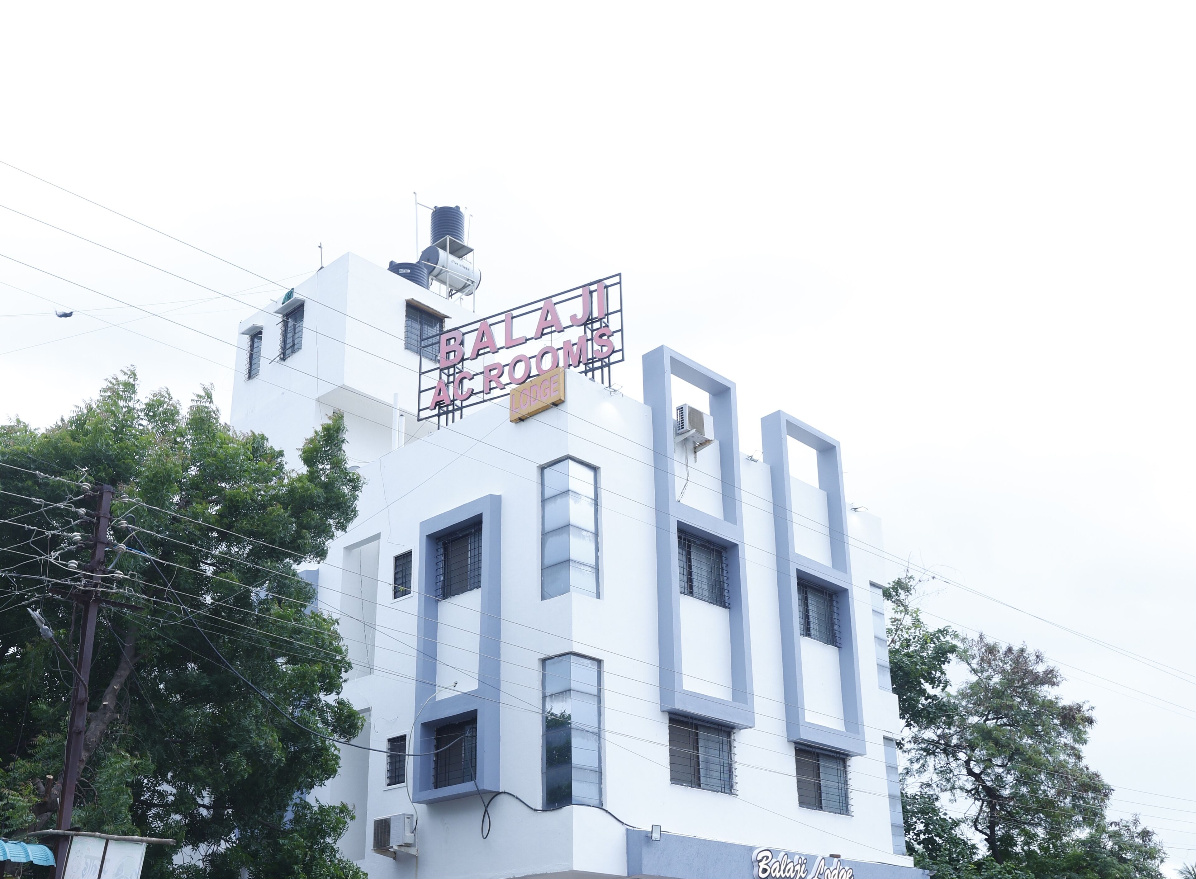 A building with a sign reading "BALAJI AC ROOM" and "Lodge".