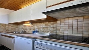 A kitchen with white cabinets, a stainless steel sink, and a built-in oven.