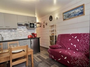 Cozy living space with a kitchenette, dining table, and comfortable sofa.