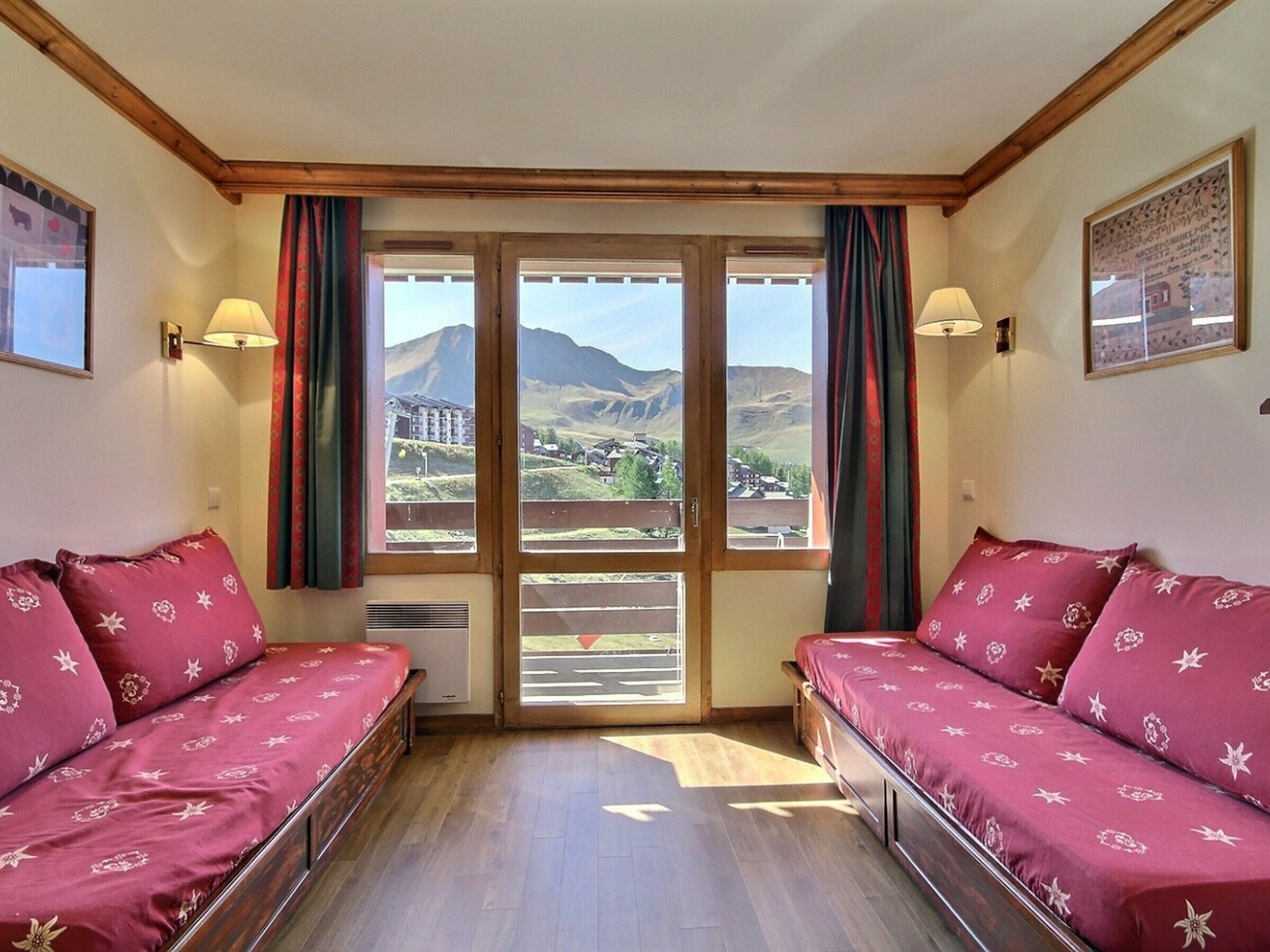 Una habitación con dos camas, ventanas amplias y vistas a un paisaje montañoso.