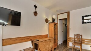 A wooden room with a desk, two stools, a cabinet, and a mirror. - Renovated studio 3 pers, south-facing with balcony in La Plagne (La Plagne)
