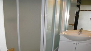 Une salle de bain comprenant des toilettes, un lavabo et un espace douche.