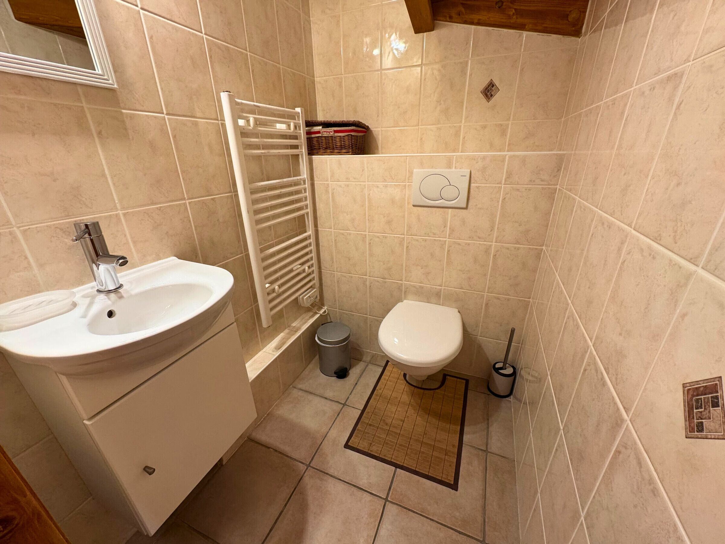 A bathroom with a sink, toilet, and towel rack.