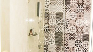 A bathroom with a toilet, sink, and shower area.