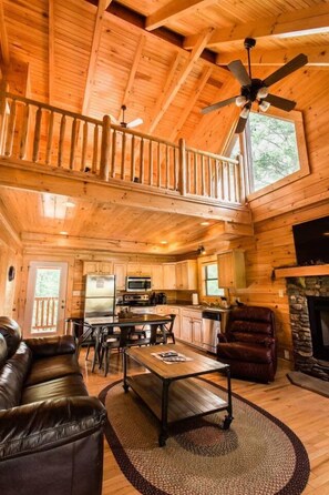 A spacious cabin interior with a dining area, kitchen, and a fireplace. - 10 Min 2 Pigeon Forge Pkwy/Gorgeous Cabin/Hot Tub (Pigeon Forge)