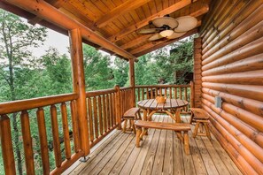 A wooden deck with a table and benches, surrounded by a wooden railing, overlooking a forested area. - 10 Min 2 Pigeon Forge Pkwy/Gorgeous Cabin/Hot Tub (Pigeon Forge)