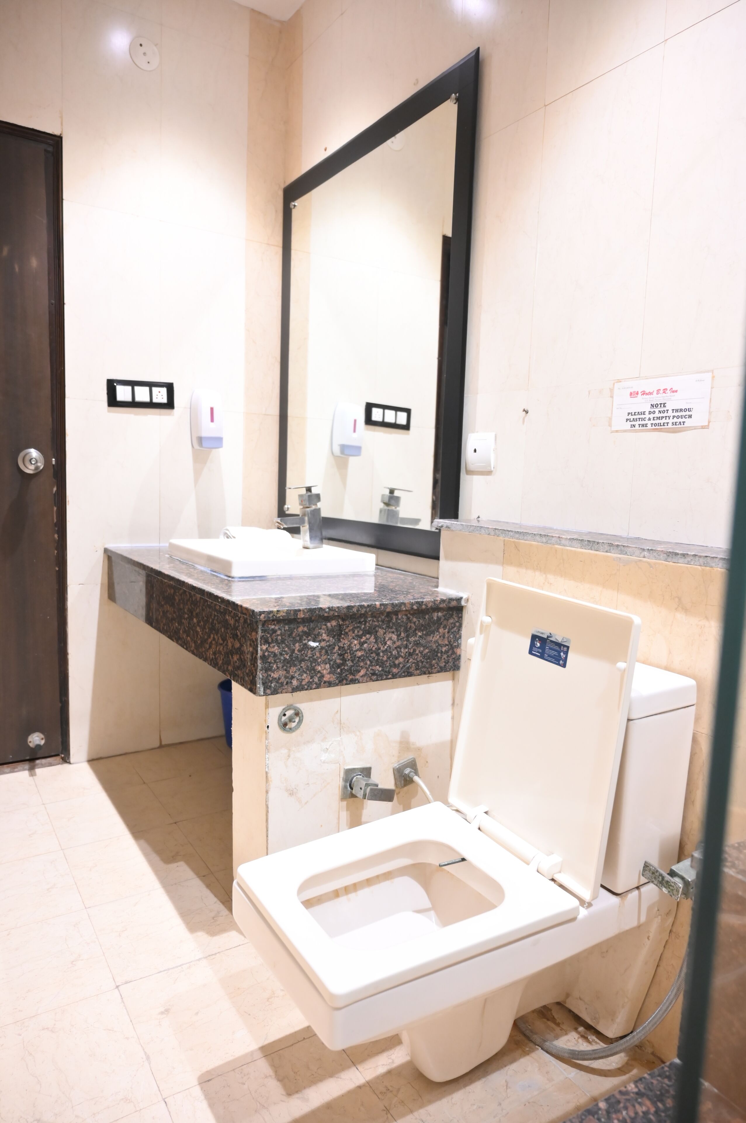 A bathroom with a toilet, sink, and mirror.