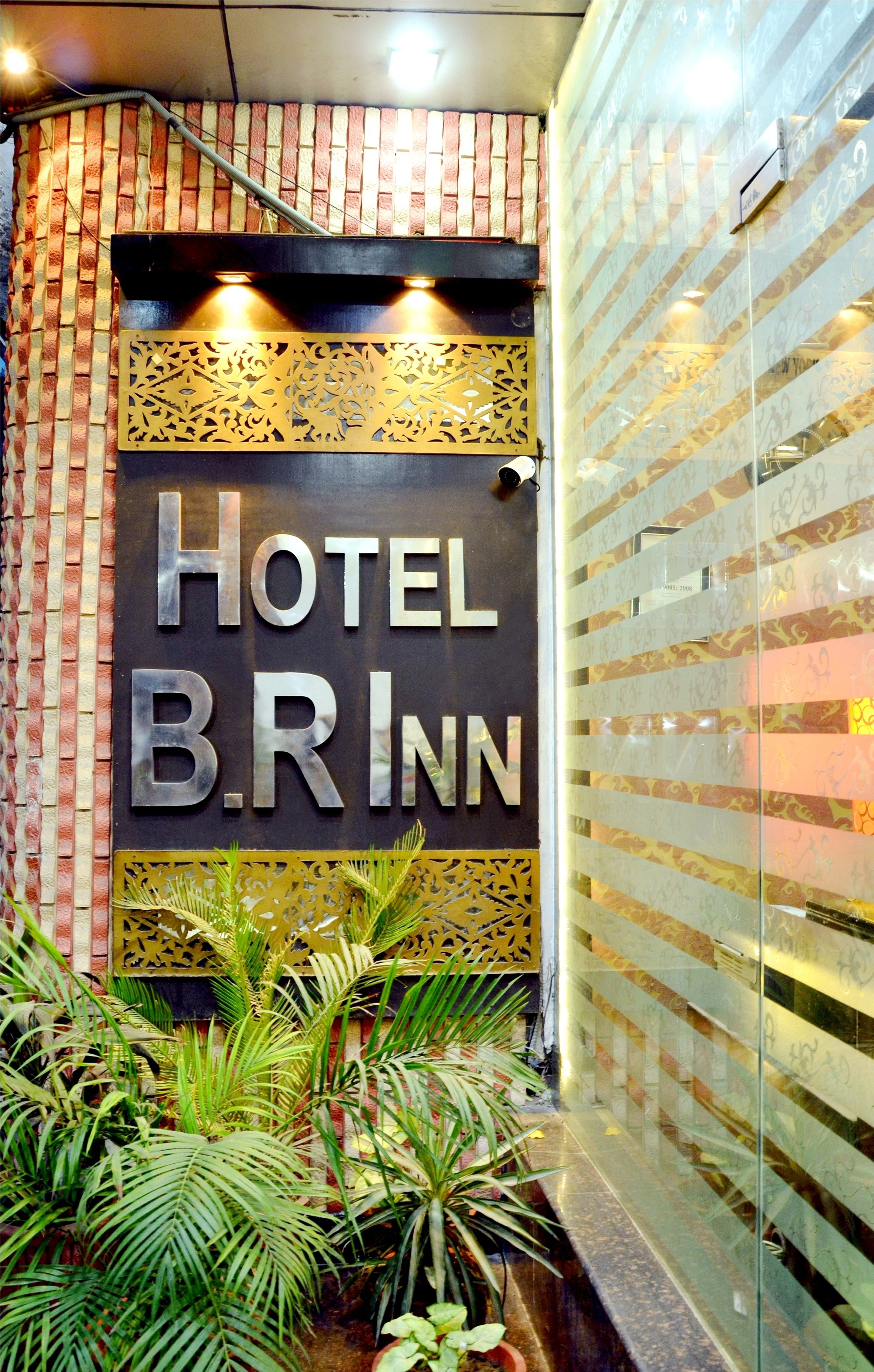 A hotel entrance with a sign reading "HOTEL B.RINN" and decorative panels.