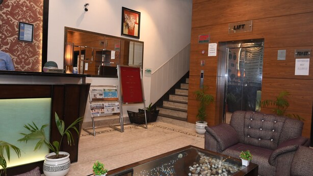 Zona de recepción con mostrador, escalera y ascensor.