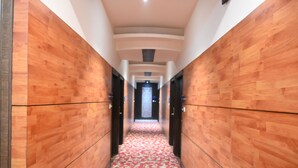 Un pasillo con paredes de madera y una alfombra roja.